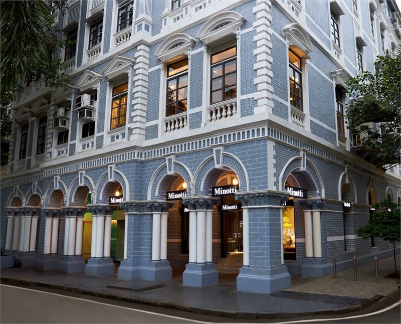 Exterior of the Minotti monobrand showroom in Mumbai, set in a blue and white heritage building with arcaded columns